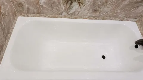 Same bathtub after refinishing, with a glossy white finish